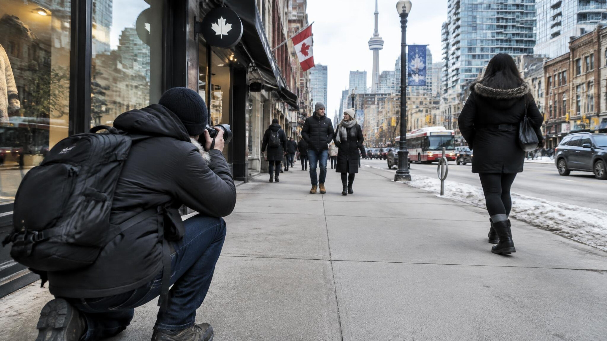 Photographer crouched taking a photo of a city street scene
